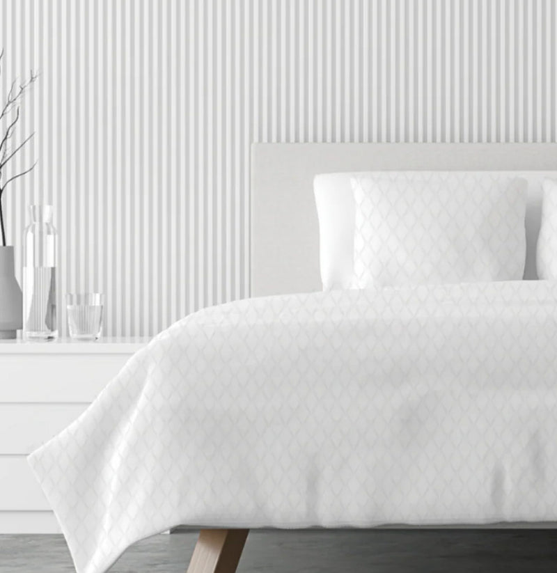 A bed made up in white Lusome Temperature-Regulating Sheets